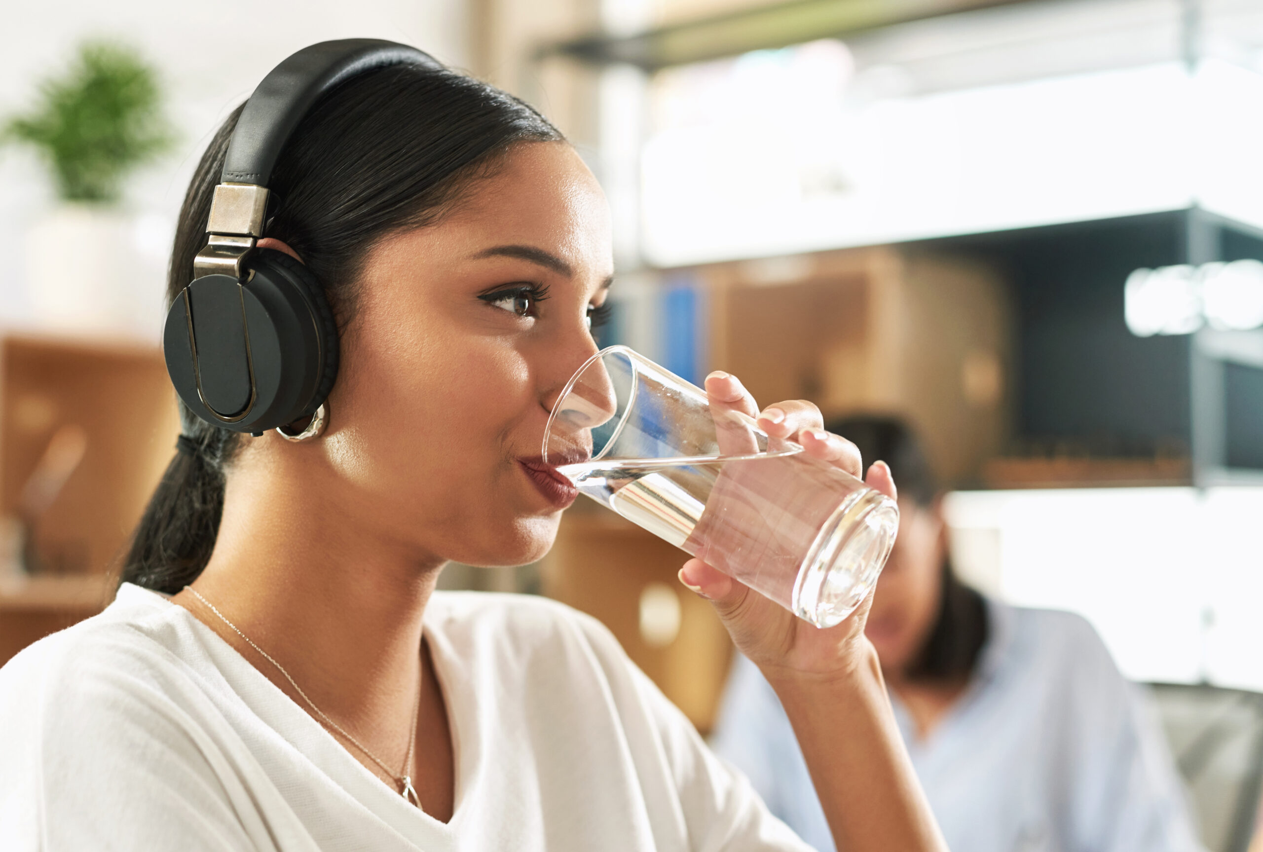 A person drinking water from a glass to stay hydrated and prevent dry mouth.